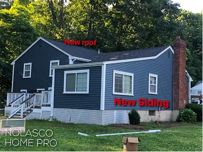 Blue-gray suburban house with white trim, labeled “New roof” and “New Siding,” showing a refreshed exterior, front steps, lawn, and leafy trees.