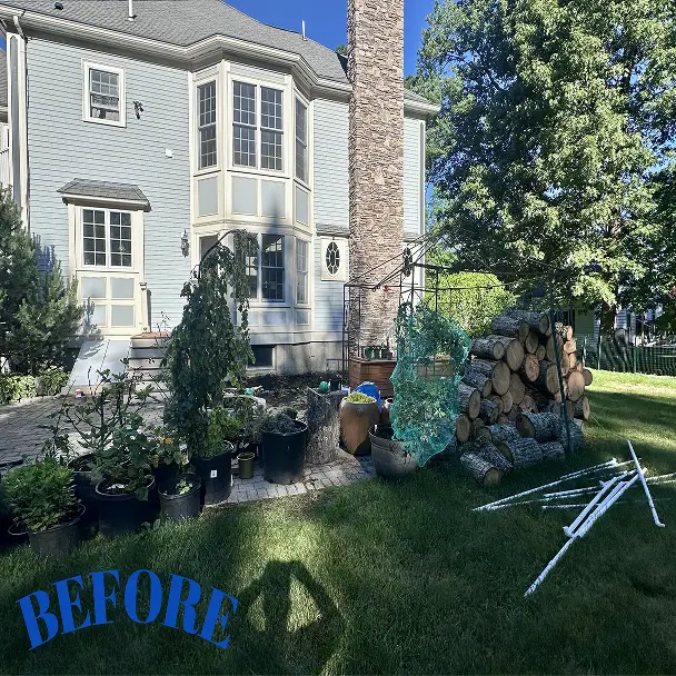 Before: Sunny backyard beside a pale blue Victorian-style house, with potted plants, stacked firewood, garden fencing, and a swing frame.