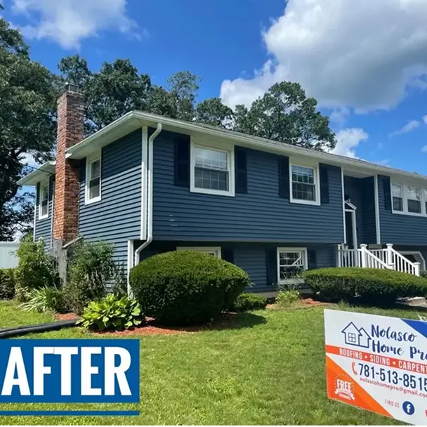βAfterβ photo of a renovated blue-sided suburban home with brick chimney, manicured shrubs, bright sky, and a roofing company sign.